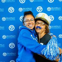 Two alumni hug each other for a photo